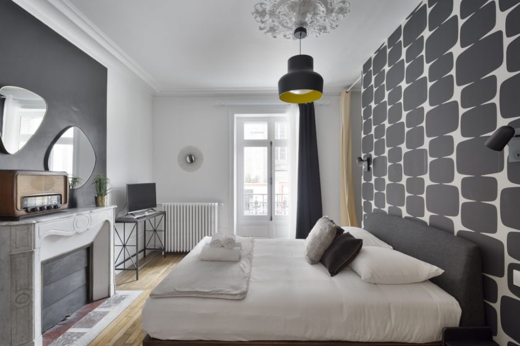 Chambre avec dressing noir et beige, cheminée ancienne, miroirs, poste de radio ancien chiné déco